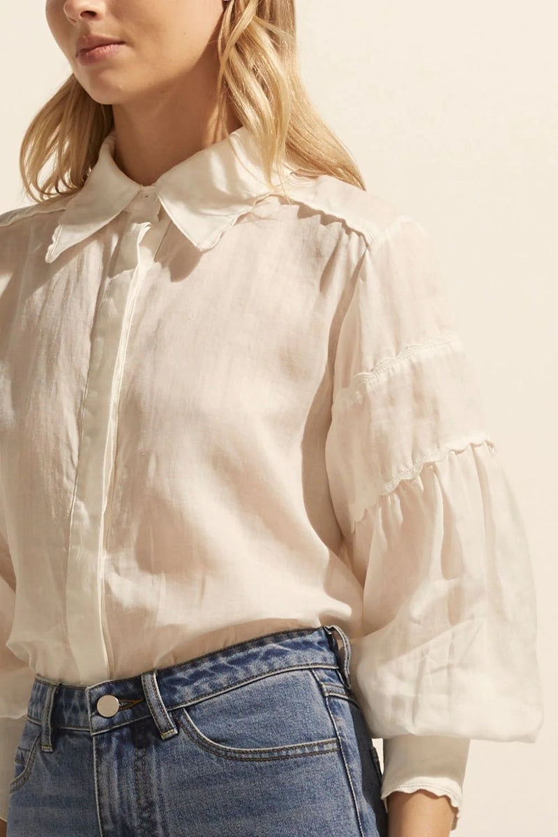 the epitome of versatile sophistication, the dash top is tailored to balance a classic aesthetic with modern ease. the shirt's structure is softened by romantic gathered sleeves a scalloped trimmed collar for fresh feminine finesse.  color: cream