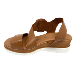 Made in Spain, this soft unlined leather wedged sandal has an angled strap across the instep finishing in a round rattan looking buckle, a memory foam insole and a white sole. 
