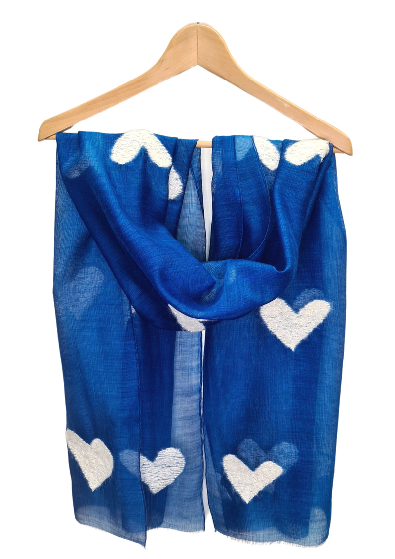 This beautifully fine scarf is 85% wool and 15% silk and is embroidered with hearts in cream wool. Available in vibrant blue and rose.