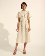 Understated yet alluring with a comfortable off the body fit the Unfurl is both modern and feminine. A midi hemline, ruffled neckline and button through style gives you the freedom to wear it as demure, or as daring as you please. This linen blend makes for a great travel companion, while the self-tie fabric belt lets you tailor to your waistline. A ruffled neckline and curved lace trim make this elegant dress ideal for any occasion.  