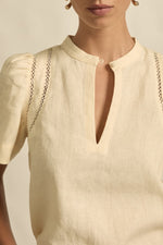 quietly elevated blouse, the Recollect top combines tailoring with soft details.&nbsp;

Lace accents and tulip sleeves lend charm to a clean-lined silhouette.

100% linen composition
circular lace detailing at the shoulder
v-neck split with covered dome button
short gathered tulip sleeve
neat, refined structure