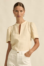 quietly elevated blouse, the Recollect top combines tailoring with soft details.&nbsp;

Lace accents and tulip sleeves lend charm to a clean-lined silhouette.

100% linen composition
circular lace detailing at the shoulder
v-neck split with covered dome button
short gathered tulip sleeve
neat, refined structure