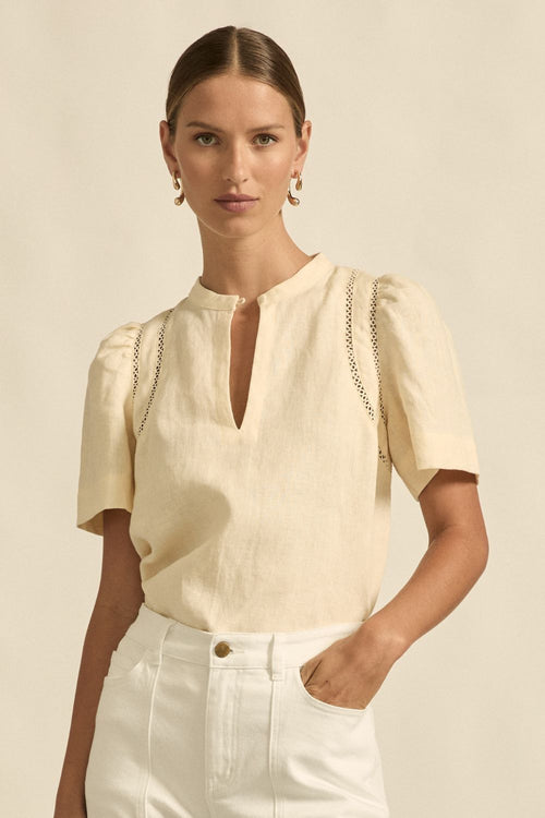 quietly elevated blouse, the Recollect top combines tailoring with soft details.&nbsp;

Lace accents and tulip sleeves lend charm to a clean-lined silhouette.

100% linen composition
circular lace detailing at the shoulder
v-neck split with covered dome button
short gathered tulip sleeve
neat, refined structure