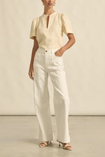 quietly elevated blouse, the Recollect top combines tailoring with soft details.&nbsp;

Lace accents and tulip sleeves lend charm to a clean-lined silhouette.

100% linen composition
circular lace detailing at the shoulder
v-neck split with covered dome button
short gathered tulip sleeve
neat, refined structure
