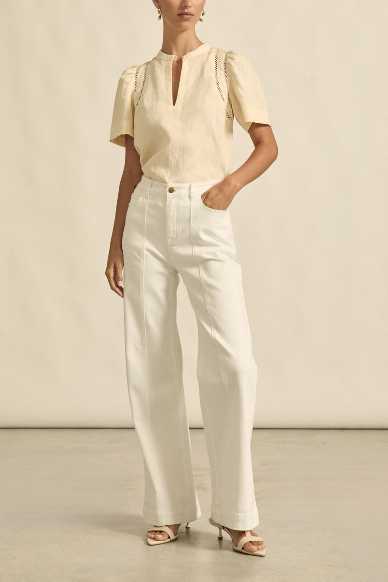 quietly elevated blouse, the Recollect top combines tailoring with soft details.&nbsp;

Lace accents and tulip sleeves lend charm to a clean-lined silhouette.

100% linen composition
circular lace detailing at the shoulder
v-neck split with covered dome button
short gathered tulip sleeve
neat, refined structure