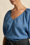 quietly elevated blouse, the Recollect top combines tailoring with soft details.&nbsp;

Lace accents and tulip sleeves lend charm to a clean-lined silhouette.

100% linen composition
circular lace detailing at the shoulder
v-neck split with covered dome button
short gathered tulip sleeve
neat, refined structure