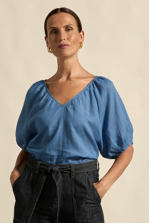 quietly elevated blouse, the Recollect top combines tailoring with soft details.&nbsp;

Lace accents and tulip sleeves lend charm to a clean-lined silhouette.

100% linen composition
circular lace detailing at the shoulder
v-neck split with covered dome button
short gathered tulip sleeve
neat, refined structure