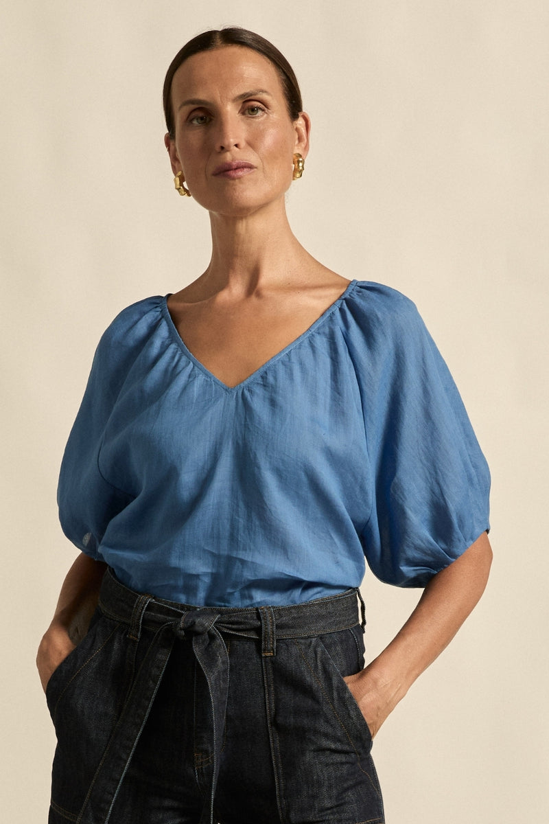 quietly elevated blouse, the Recollect top combines tailoring with soft details.&nbsp;

Lace accents and tulip sleeves lend charm to a clean-lined silhouette.

100% linen composition
circular lace detailing at the shoulder
v-neck split with covered dome button
short gathered tulip sleeve
neat, refined structure