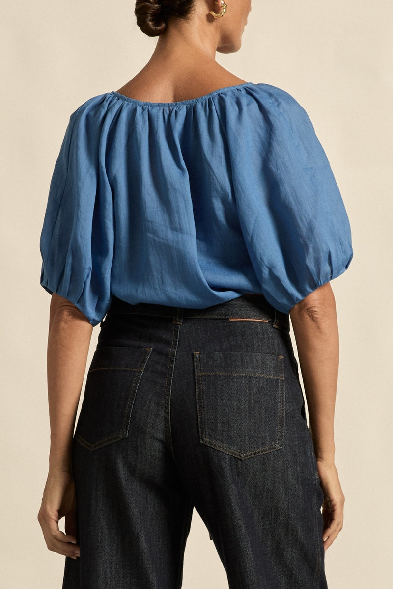 quietly elevated blouse, the Recollect top combines tailoring with soft details.&nbsp;

Lace accents and tulip sleeves lend charm to a clean-lined silhouette.

100% linen composition
circular lace detailing at the shoulder
v-neck split with covered dome button
short gathered tulip sleeve
neat, refined structure