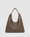 The Louenhide Avery Mocha Shoulder Bag is a modern take on the classic hobo bag with an elevated twist. The whipstitch detailing adds depth and texture to the shoulder bags exterior while the slouchy, minimalistic design adds a soft yet sleek element to your capsule wardrobe. The seamless teardrop silhouette sits comfortably over the shoulder, while offering ample interior space to fit your everyday essentials and more. With its timeless blend of structure and softness, elevate your everyday with the Avery 