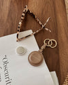 The Opal Mocha AirTag Case is a refined travel essential designed to bring both elegance and ease to your journey. Designed in a smooth vegan leather, Opal Mocha securely holds your Apple AirTag with a sleek press-stud closure, keeping your valuables traceable without compromising on style. Whether clipped to your handbag, keyring, or slipped inside your suitcase, Opal Mocha’s compact silhouette and easy-clip ring make her a subtle yet sophisticated addition to your travel routine. Lightweight, minimal, and