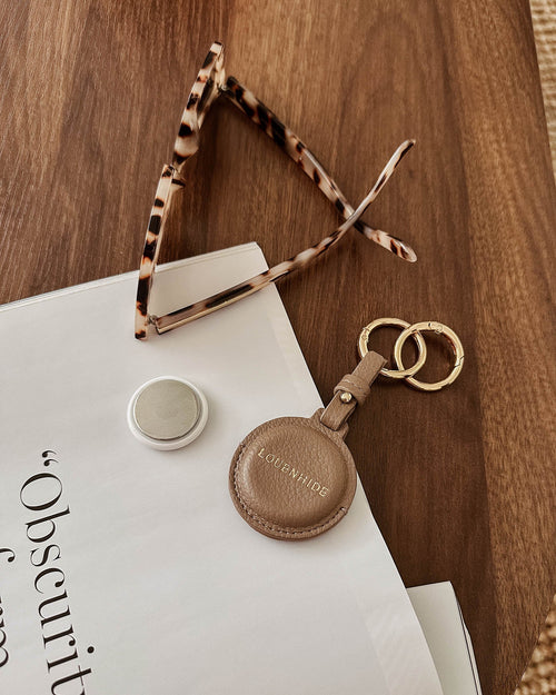The Opal Mocha AirTag Case is a refined travel essential designed to bring both elegance and ease to your journey. Designed in a smooth vegan leather, Opal Mocha securely holds your Apple AirTag with a sleek press-stud closure, keeping your valuables traceable without compromising on style. Whether clipped to your handbag, keyring, or slipped inside your suitcase, Opal Mocha’s compact silhouette and easy-clip ring make her a subtle yet sophisticated addition to your travel routine. Lightweight, minimal, and