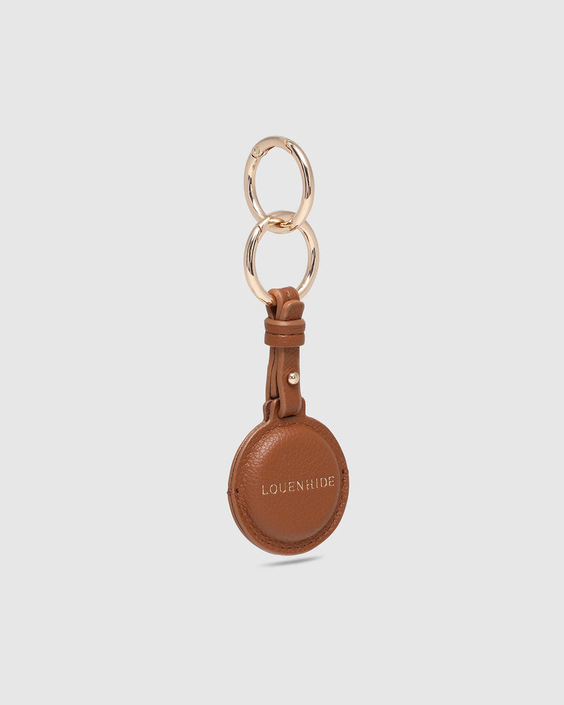 The Opal Mocha AirTag Case is a refined travel essential designed to bring both elegance and ease to your journey. Designed in a smooth vegan leather, Opal Mocha securely holds your Apple AirTag with a sleek press-stud closure, keeping your valuables traceable without compromising on style. Whether clipped to your handbag, keyring, or slipped inside your suitcase, Opal Mocha’s compact silhouette and easy-clip ring make her a subtle yet sophisticated addition to your travel routine. Lightweight, minimal, and
