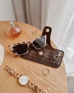 The Louenhide Skittle Sunglass Case is the perfect blend of style and functionality for your everyday eyewear. For ultimate convenience, effortlessly attach to your keys or handbag with the light gold hardware keyring clasp. Without compromising on style, the exterior features a gorgeous vegan leather, while the interior is lined with soft suede material to keep your everyday eyewear protected. Whether it's your favourite sunglasses or your reading glasses, they will stay protected and safe with the secure 