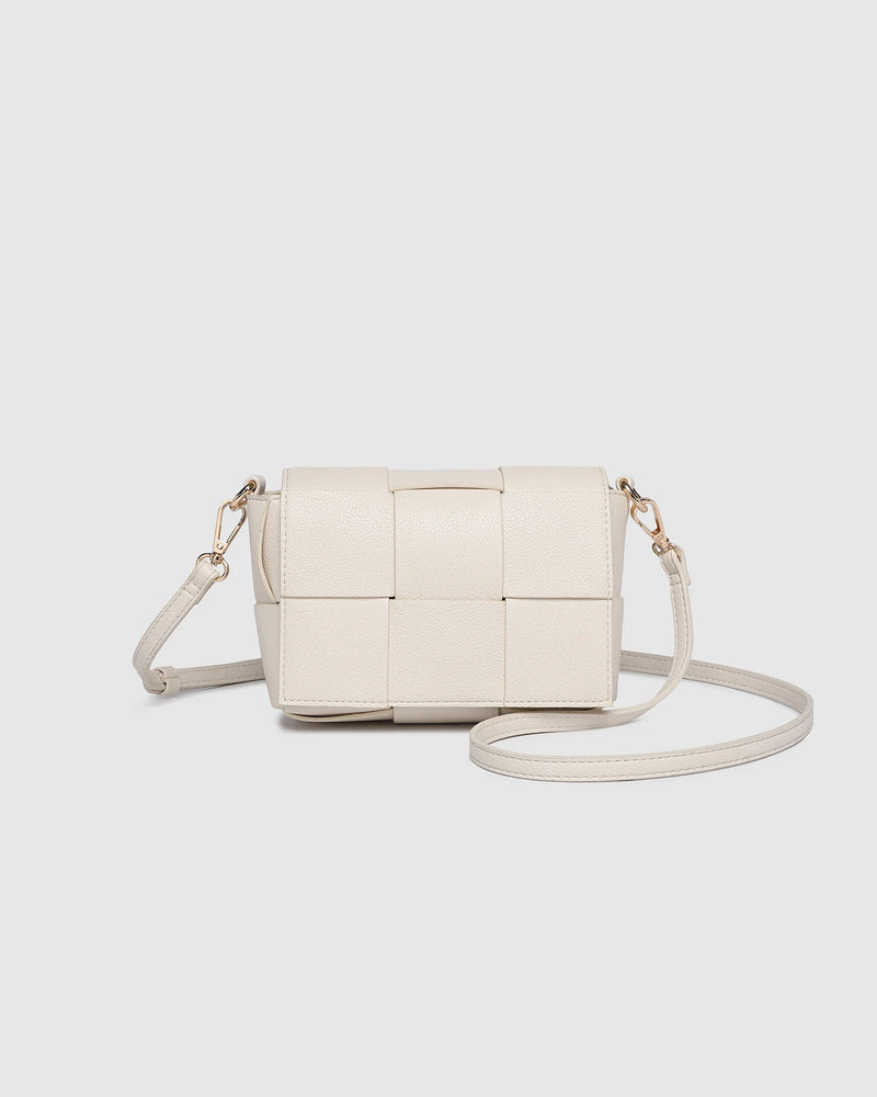 The Josephine Vanilla Crossbody Bag is a statement in both texture and versatility, designed to deliver effortless elegance from day to night. Crafted from woven vegan leather panels, she offers a modern twist on classic texture, adding a refined edge to everyday styling. This women’s woven handbag features a structured silhouette with a magnetic closure to keep your essentials secure, while light gold hardware lends a polished finish. With two interchangeable straps: a sleek vegan leather crossbody and a g