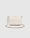 The Josephine Vanilla Crossbody Bag is a statement in both texture and versatility, designed to deliver effortless elegance from day to night. Crafted from woven vegan leather panels, she offers a modern twist on classic texture, adding a refined edge to everyday styling. This women’s woven handbag features a structured silhouette with a magnetic closure to keep your essentials secure, while light gold hardware lends a polished finish. With two interchangeable straps: a sleek vegan leather crossbody and a g