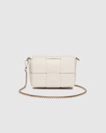 The Josephine Vanilla Crossbody Bag is a statement in both texture and versatility, designed to deliver effortless elegance from day to night. Crafted from woven vegan leather panels, she offers a modern twist on classic texture, adding a refined edge to everyday styling. This women’s woven handbag features a structured silhouette with a magnetic closure to keep your essentials secure, while light gold hardware lends a polished finish. With two interchangeable straps: a sleek vegan leather crossbody and a g