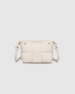 The Josephine Vanilla Crossbody Bag is a statement in both texture and versatility, designed to deliver effortless elegance from day to night. Crafted from woven vegan leather panels, she offers a modern twist on classic texture, adding a refined edge to everyday styling. This women’s woven handbag features a structured silhouette with a magnetic closure to keep your essentials secure, while light gold hardware lends a polished finish. With two interchangeable straps: a sleek vegan leather crossbody and a g