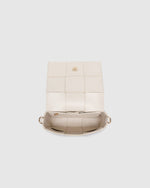 The Josephine Vanilla Crossbody Bag is a statement in both texture and versatility, designed to deliver effortless elegance from day to night. Crafted from woven vegan leather panels, she offers a modern twist on classic texture, adding a refined edge to everyday styling. This women’s woven handbag features a structured silhouette with a magnetic closure to keep your essentials secure, while light gold hardware lends a polished finish. With two interchangeable straps: a sleek vegan leather crossbody and a g