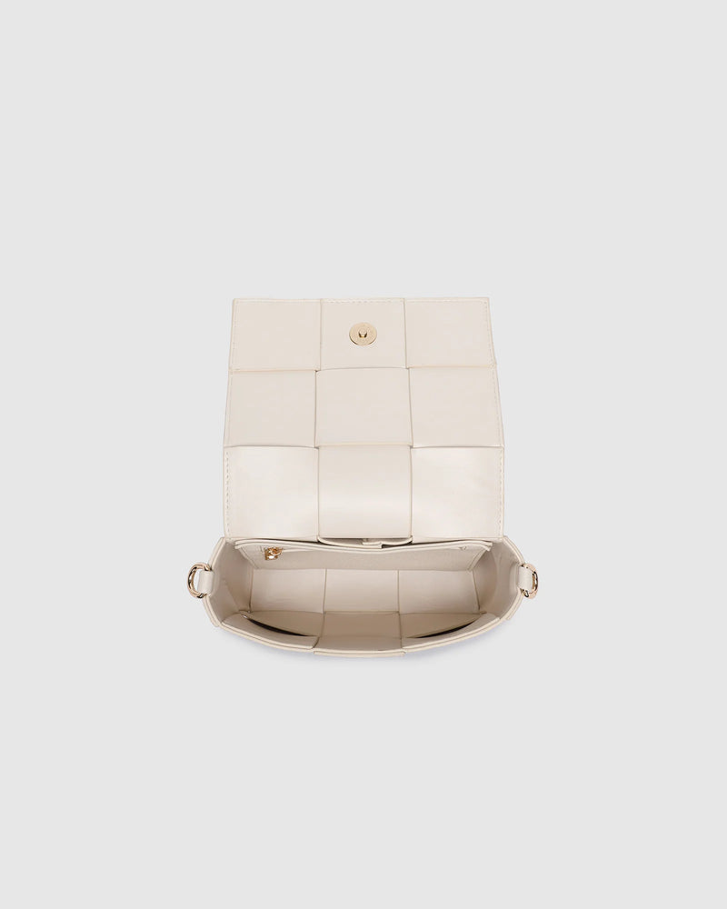 The Josephine Vanilla Crossbody Bag is a statement in both texture and versatility, designed to deliver effortless elegance from day to night. Crafted from woven vegan leather panels, she offers a modern twist on classic texture, adding a refined edge to everyday styling. This women’s woven handbag features a structured silhouette with a magnetic closure to keep your essentials secure, while light gold hardware lends a polished finish. With two interchangeable straps: a sleek vegan leather crossbody and a g