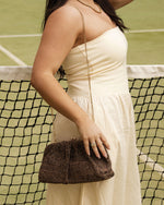 he Goldie Raffia Vanilla Clutch is your statement plus-one for any occasion, designed to elevate your look from daytime celebrations to evening soirées. This evening clutch features a slouchy yet structured silhouette, crafted in a raffia-like texture for a modern take on timeless texture. As a true gold chain clutch, Goldie Raffia Vanilla is finished with both a short and long gold chain strap, giving you the freedom to wear her in hand, over the shoulder, or crossbody. A polished kiss clip closure keeps y
