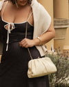 he Goldie Raffia Vanilla Clutch is your statement plus-one for any occasion, designed to elevate your look from daytime celebrations to evening soirées. This evening clutch features a slouchy yet structured silhouette, crafted in a raffia-like texture for a modern take on timeless texture. As a true gold chain clutch, Goldie Raffia Vanilla is finished with both a short and long gold chain strap, giving you the freedom to wear her in hand, over the shoulder, or crossbody. A polished kiss clip closure keeps y