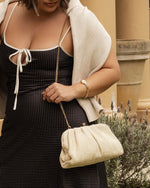 he Goldie Raffia Vanilla Clutch is your statement plus-one for any occasion, designed to elevate your look from daytime celebrations to evening soirées. This evening clutch features a slouchy yet structured silhouette, crafted in a raffia-like texture for a modern take on timeless texture. As a true gold chain clutch, Goldie Raffia Vanilla is finished with both a short and long gold chain strap, giving you the freedom to wear her in hand, over the shoulder, or crossbody. A polished kiss clip closure keeps y