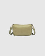 The Louenhide Saylor Sage Green Crossbody Bag brings a bold yet refined edge to your everyday styling. With its soft faux suede finish and sleek baguette-shaped silhouette, this cross body bag with chain detailing blends texture and refinement in all the right ways. Designed to be worn with ease but styled to stand out, the Saylor Sage Green moves effortlessly from day to night, adding impact to your layered winter looks. Wherever the day leads, this chain strap handbag is the finishing touch that completes