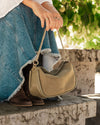 The Louenhide Saylor Sage Green Crossbody Bag brings a bold yet refined edge to your everyday styling. With its soft faux suede finish and sleek baguette-shaped silhouette, this cross body bag with chain detailing blends texture and refinement in all the right ways. Designed to be worn with ease but styled to stand out, the Saylor Sage Green moves effortlessly from day to night, adding impact to your layered winter looks. Wherever the day leads, this chain strap handbag is the finishing touch that completes