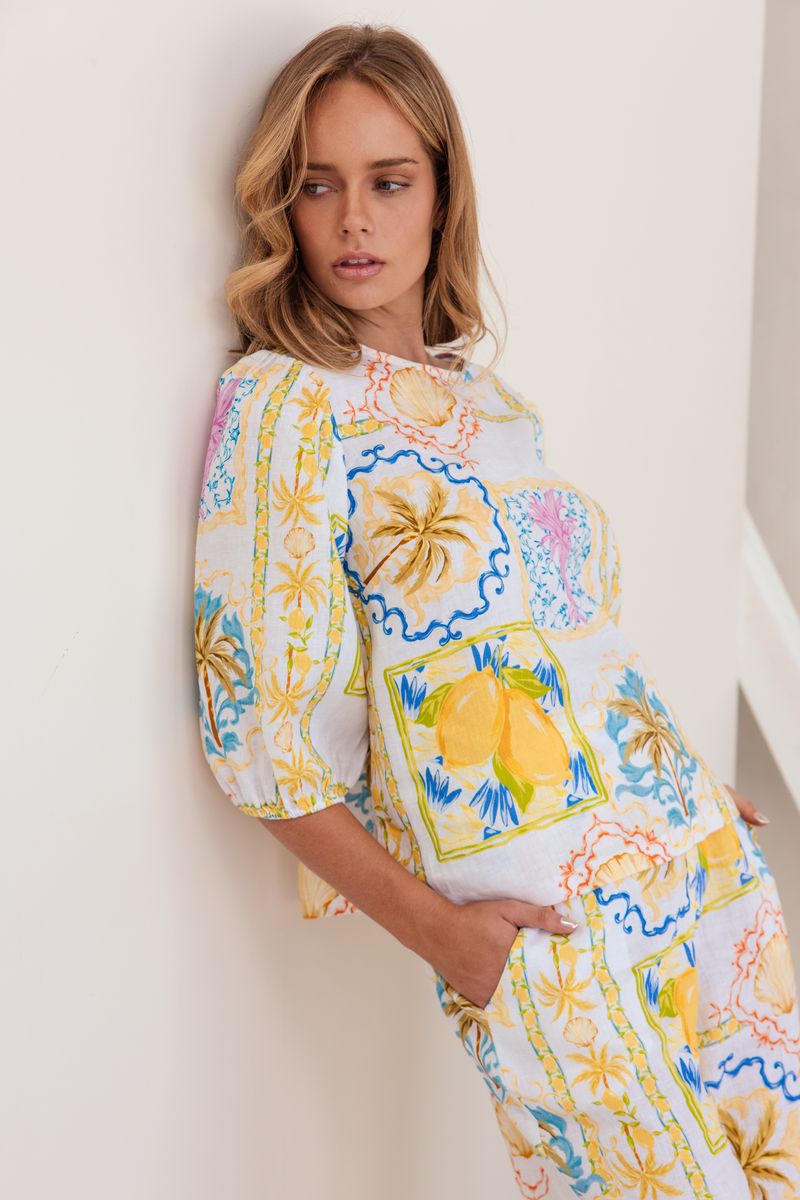 Matching shorts for your summer tops! 100% linen in the fresh Amalfi Dreams print in colours of lemon and blue, these mid length shorts have large front pockets, zip and button front, a flat band at the front and elastic at the back waist.