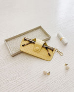 The Louenhide Skittle Sunglass Case is the perfect blend of style and functionality for your everyday eyewear. For ultimate convenience, effortlessly attach to your keys or handbag with the light gold hardware keyring clasp. Without compromising on style, the exterior features a gorgeous vegan leather, while the interior is lined with soft suede material to keep your everyday eyewear protected. Whether it's your favourite sunglasses or your reading glasses, they will stay protected and safe with the secure 