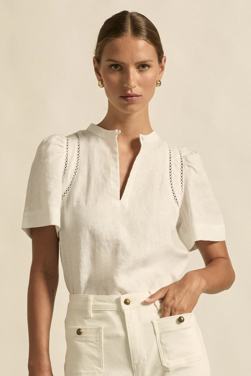 lace accents and tulip sleeves lend charm to a clean-lined silhouette.

100% linen composition
circular lace detailing at the shoulder
v-neck split with covered dome button
short gathered tulip sleeve
neat, refined structure