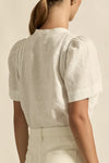 lace accents and tulip sleeves lend charm to a clean-lined silhouette.

100% linen composition
circular lace detailing at the shoulder
v-neck split with covered dome button
short gathered tulip sleeve
neat, refined structure