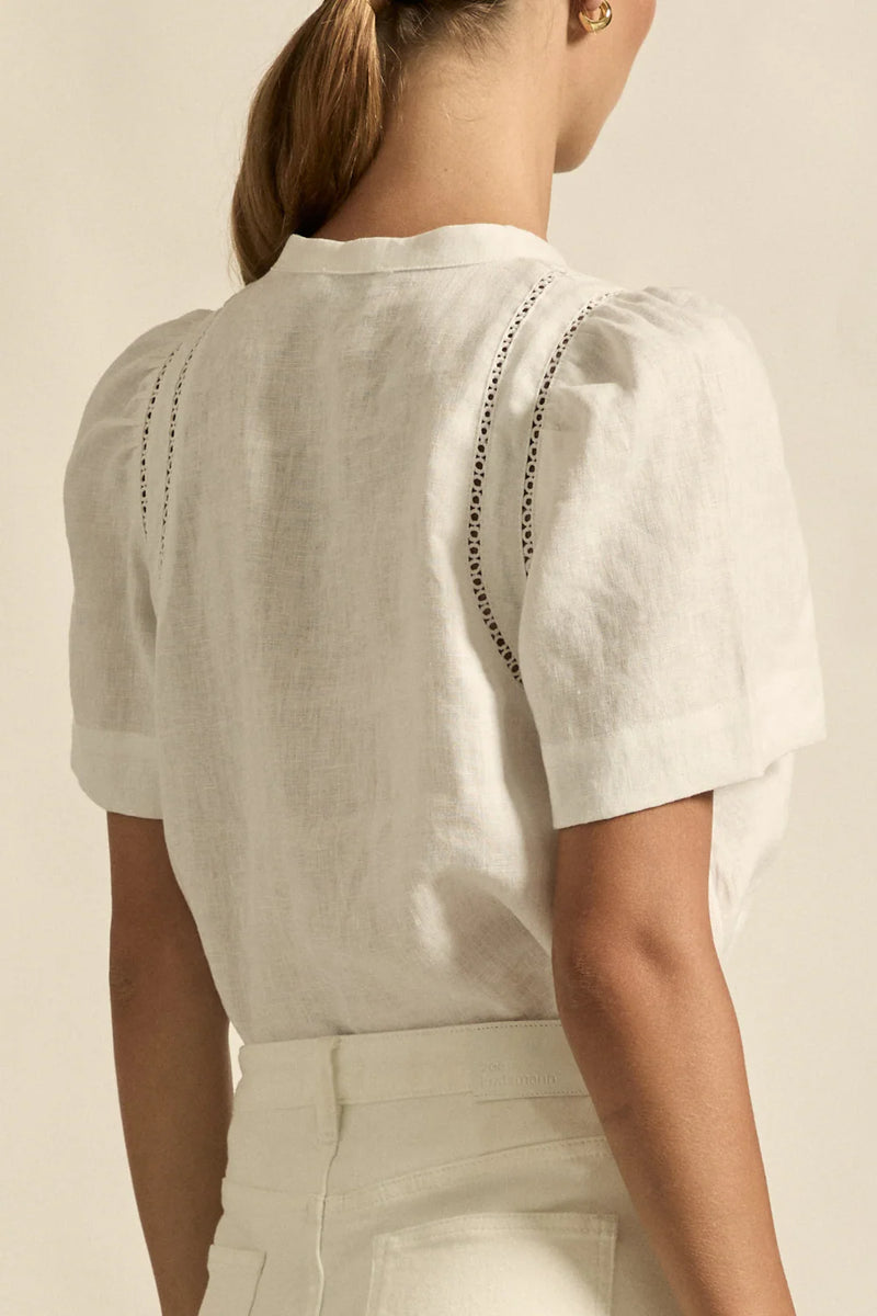 lace accents and tulip sleeves lend charm to a clean-lined silhouette.

100% linen composition
circular lace detailing at the shoulder
v-neck split with covered dome button
short gathered tulip sleeve
neat, refined structure