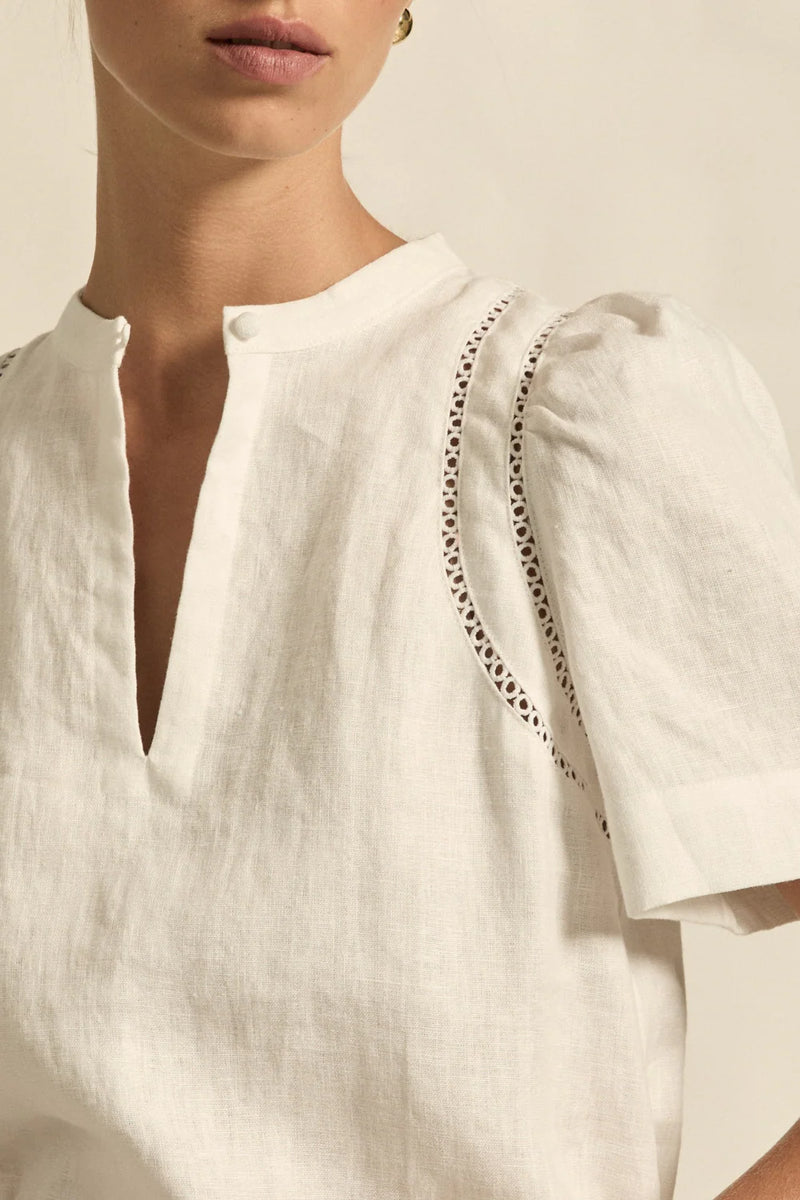 lace accents and tulip sleeves lend charm to a clean-lined silhouette.

100% linen composition
circular lace detailing at the shoulder
v-neck split with covered dome button
short gathered tulip sleeve
neat, refined structure