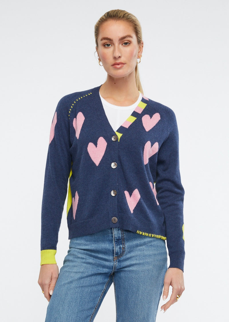 This adorably fun little cardi features pink hearts against a dark denim with a bright yellow back and cuff. Knitted from cotton and cashmere by Zaket & Plover.