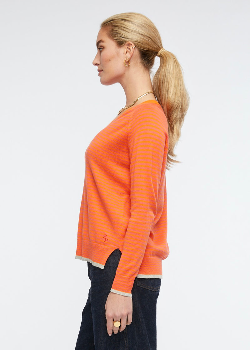 This light weight V necked jumper is perfect for your casual winter wardrobe. The stripe of vibrant fuchsia and orange is complimented by trims in a light grey. Knitted from cotton and cashmere by Zaket &amp; Plover.