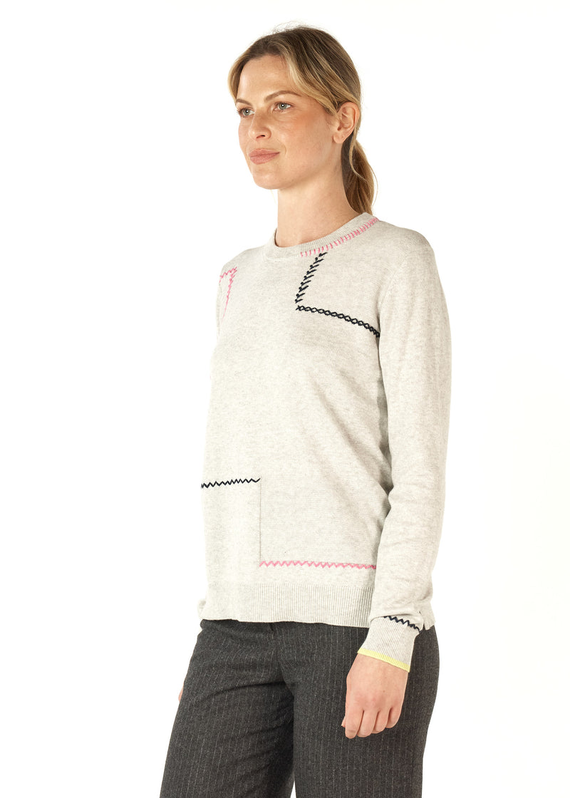 A beautifully soft knit of 5% cashmere and 95% cotton, this crew necked jumper has cross stitch and saddle stitching in black and pink wool features as well as a row of lime knitted into the bottom of each sleeve.