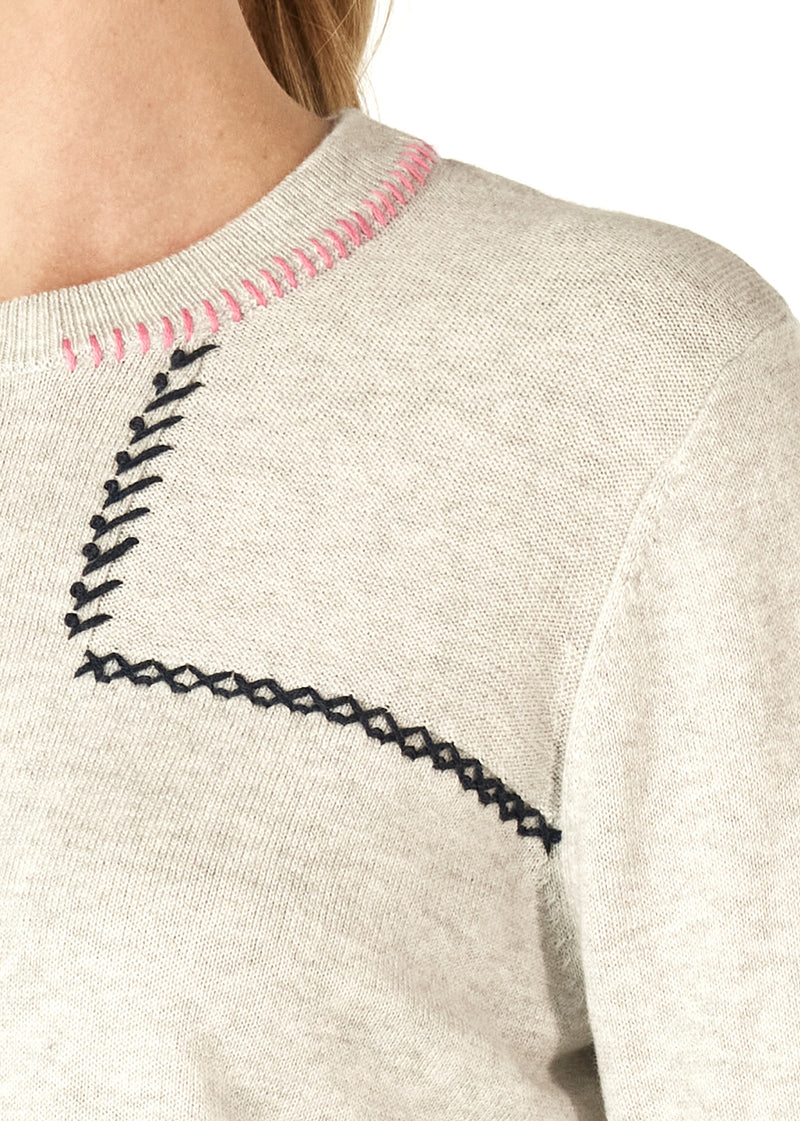 A beautifully soft knit of 5% cashmere and 95% cotton, this crew necked jumper has cross stitch and saddle stitching in black and pink wool features as well as a row of lime knitted into the bottom of each sleeve.