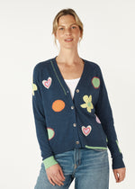 Add some fun and cuteness your winter wardrobed with our Happy Cardi. Knitted from 5% cashmere and 95% cotton yarn it features colourful heart and flower motifs, saddle stitching in wool on a mostly navy denim coloured background with lime cuffs and back.