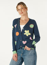 Add some fun and cuteness your winter wardrobed with our Happy Cardi. Knitted from 5% cashmere and 95% cotton yarn it features colourful heart and flower motifs, saddle stitching in wool on a mostly navy denim coloured background with lime cuffs and back.