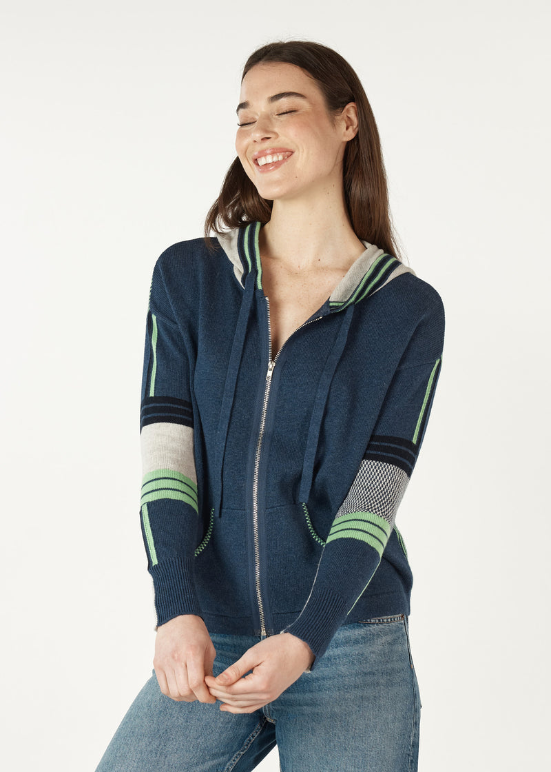  softly knitted hoodie of 5% cashmere and 95% cotton features a zipped front, pockets and feels beautiful to wear. The base colour is navy denim with a grey hood (that is edged with green stripes), Green and grey stripes and checks are features on the arms and also the back.