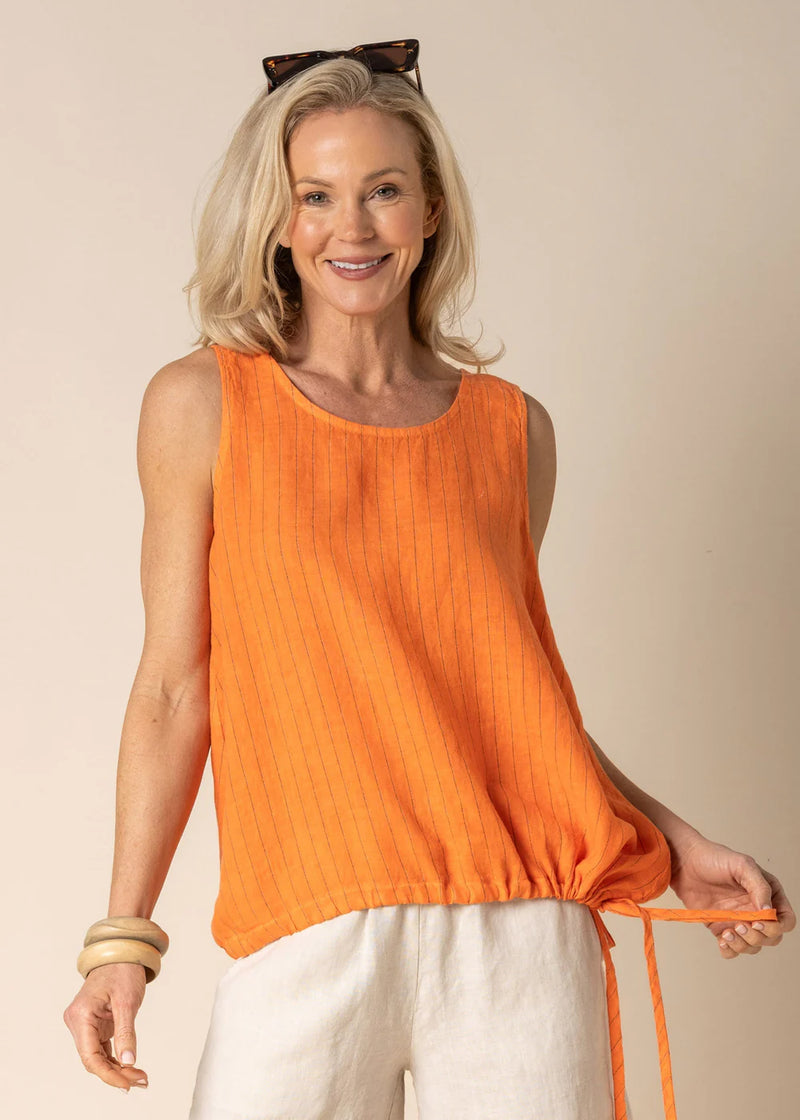 The Angela sleeveless top is a stylish and versatile linen piece, perfect for any occasion. It features a flattering scoop neck and a faint horizontal black stripe that adds subtle texture and interest to the design. The adjustable drawstring at the hem allows for a customized fit, adding a playful touch to the silhouette. A featured pleat on the back enhances the overall look, creating a gentle drape that flows beautifully with every movement. Whether dressed up or down, the Angela top is an effortless cho