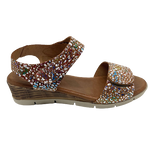 This comfort sandal on a wedge has an extremely soft foot bed, a Y back with velcro fastening on both the upper strap and on the wide strap across the toes. The tan leather is speckled with coloured and silvery splashes. Made in Spain.
