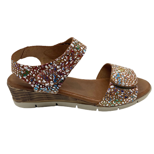 This comfort sandal on a wedge has an extremely soft foot bed, a Y back with velcro fastening on both the upper strap and on the wide strap across the toes. The tan leather is speckled with coloured and silvery splashes. Made in Spain.