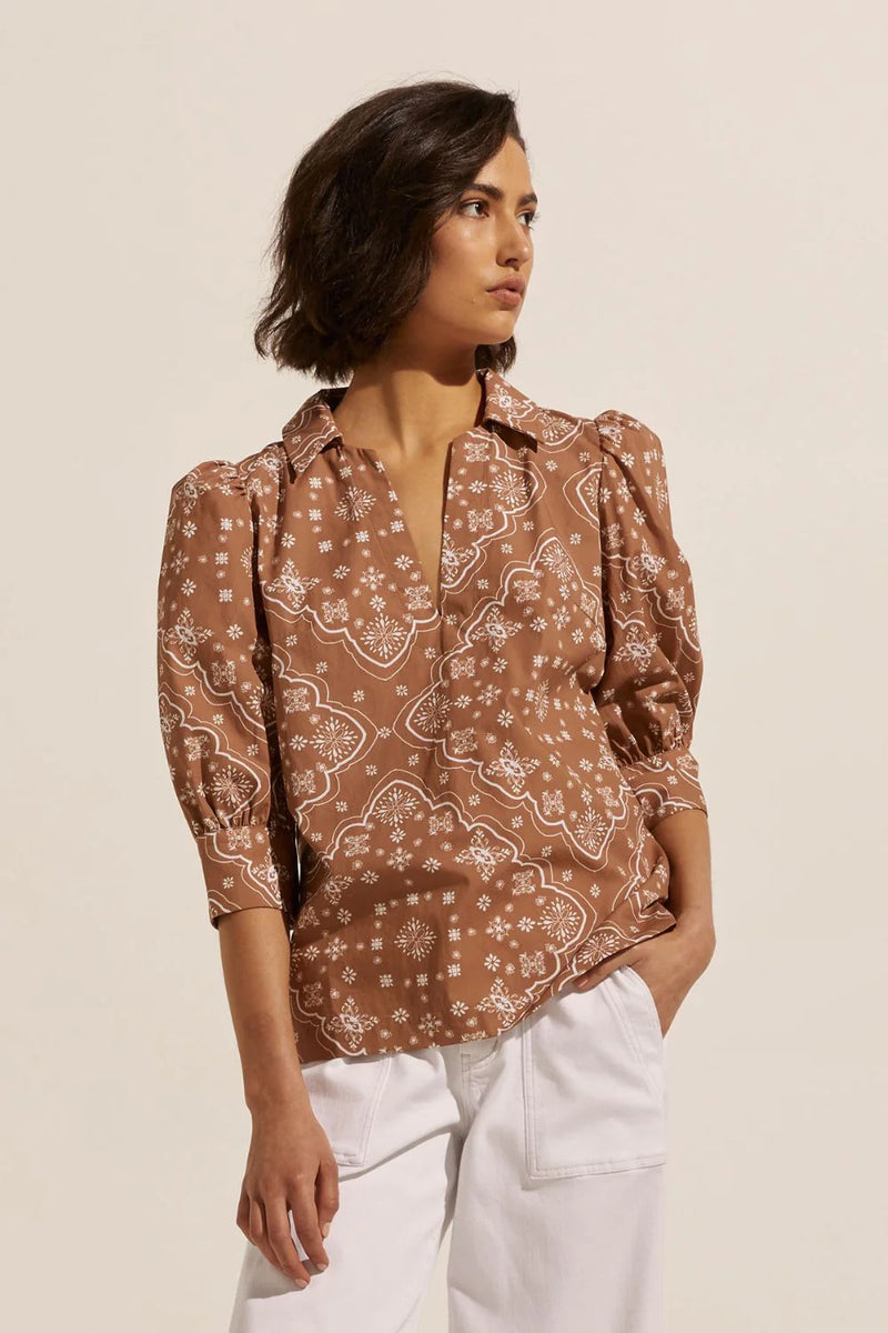 A stylish and modern piece that cuts a flattering silhouette. A deep v neckline with an open-collar and a gathered blouson sleeve are simple and chic. Small side splits create a finished hemline that is perfect to wear untucked. The clarity is a refined essential for spring dressing. 