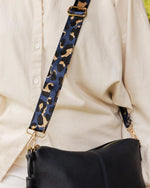 The Louenhide Daisy Crossbody Bag with Tyler Strap is a gorgeously soft and slouchy bag, styled with a trending camouflage print guitar strap! Secure your essentials in the two slip pockets, one zip pocket, and a backside zip pocket. Complete with a tassel and two adjustable and detachable straps, the Daisy is a relaxed and understated large crossbody bag style that is perfect for everyday use. If the Daisy Crossbody Bag is too big for you, shop the smaller version - The Kasey Crossbody Bag.