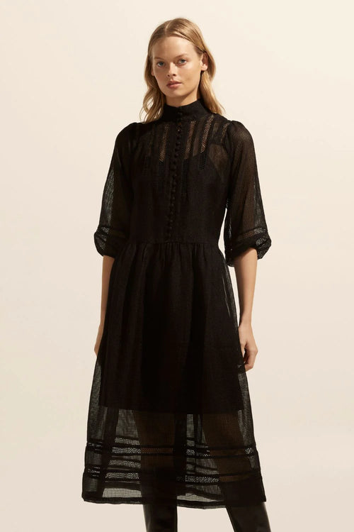 This romantic piece is the ideal trans-seasonal dress. Crafted in semi sheer window grid design this luxurious fabric offers lightness whilst remaining elevated. A high stand collar with covered buttons is punctuated by lace trim. 