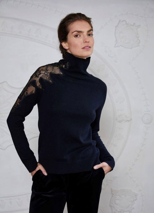 This elegant turtle neck, slim fit sweater is of cotton/wool mix. It has a lace insert across the right shoulder and and up into the neck. It looks wonderful on it's own and just as good under your favourite jacket.