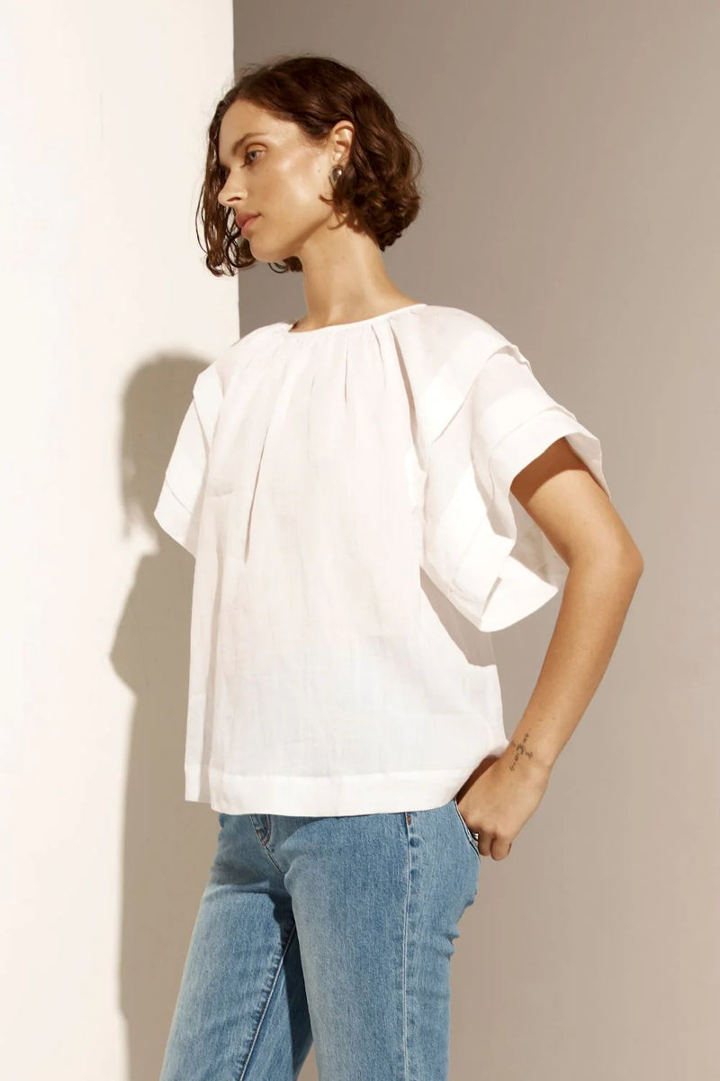 The Flout top is a study in relaxed sophistication, featuring a gathered neckline and pintuck details on the sleeves that create a modern silhouette. Its raglan sleeve offers a laid-back elegance, making it a perfect choice for easy, everyday wear.&nbsp;

This top transitions seamlessly from work to weekend with its refined simplicity.

composition: 100% ramie
softly gathered neckline is flattering and feminine
pintuck detail on a flutter style sleeve